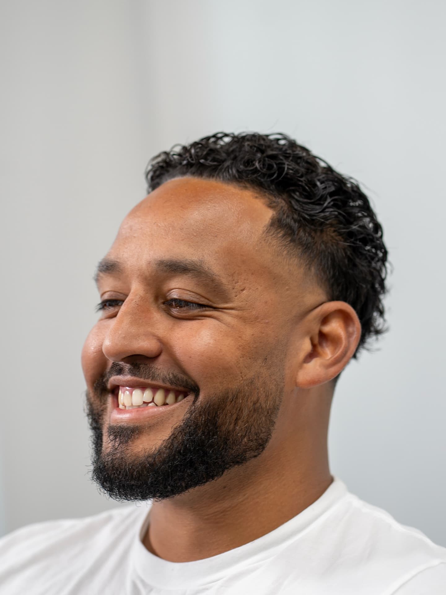 Natural curls paired with a tailored, sculpted beard