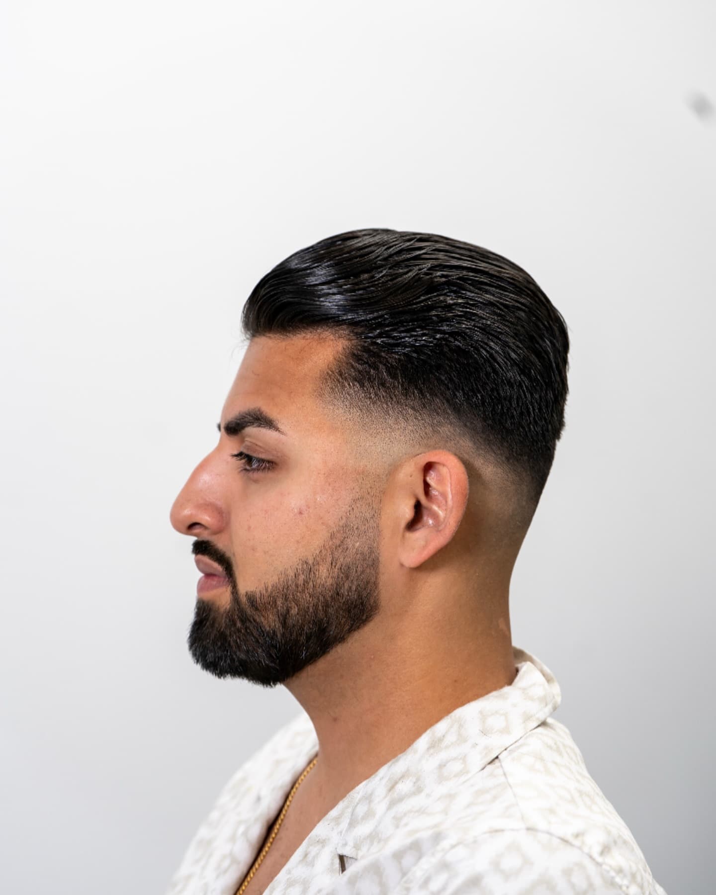 Classic slick-back with a sharp lineup and low fade